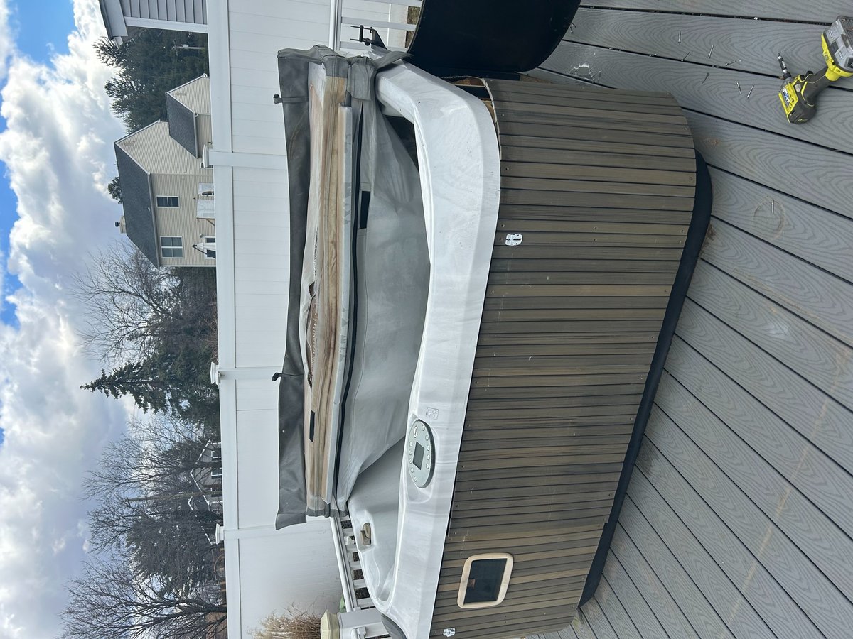 White hot tub on a deck awaiting removal